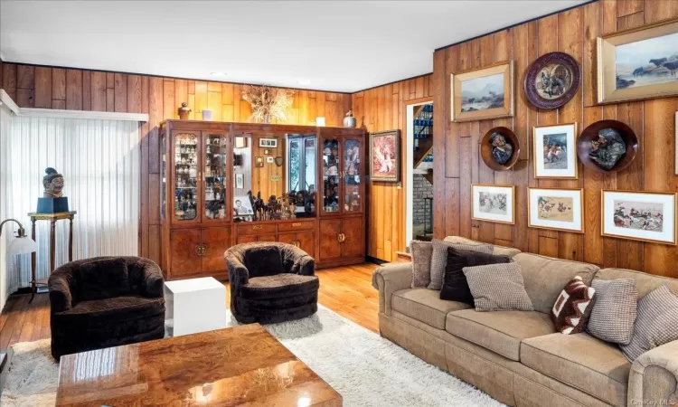 Living room featuring wooden walls and light hardwood / wood-style flooring