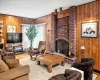 Living room with hardwood / wood-style flooring, wood walls, and a fireplace