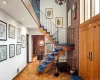 Stairway featuring parquet flooring, a brick fireplace, and brick wall