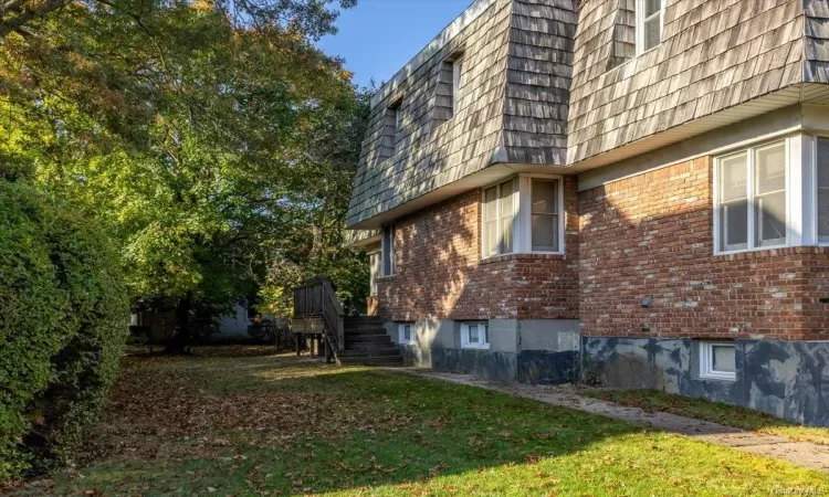 View of side of property featuring a lawn