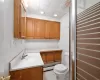 Bathroom with vanity, crown molding, a baseboard radiator, tile patterned flooring, and toilet