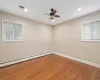 Empty room featuring ceiling fan, a baseboard radiator, and wood-type flooring