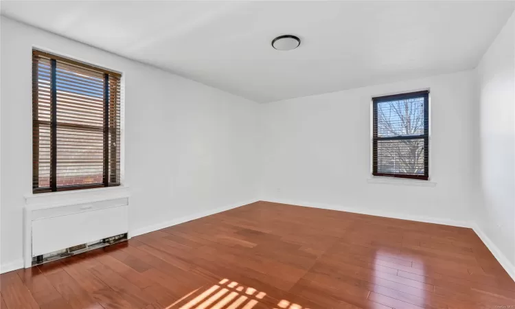 Unfurnished room with wood-type flooring and plenty of natural light