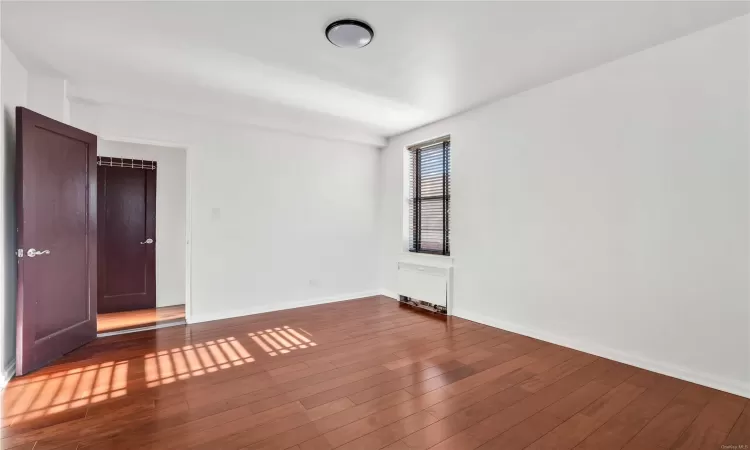 Empty room with hardwood / wood-style flooring