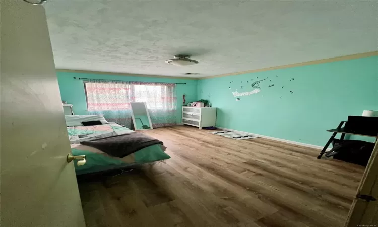 Bedroom featuring wood-type flooring and a textured ceiling