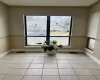 Living area with light tile patterned floors, a wealth of natural light, and crown molding