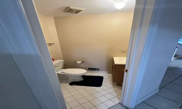 Bathroom with tile patterned floors, vanity, and toilet