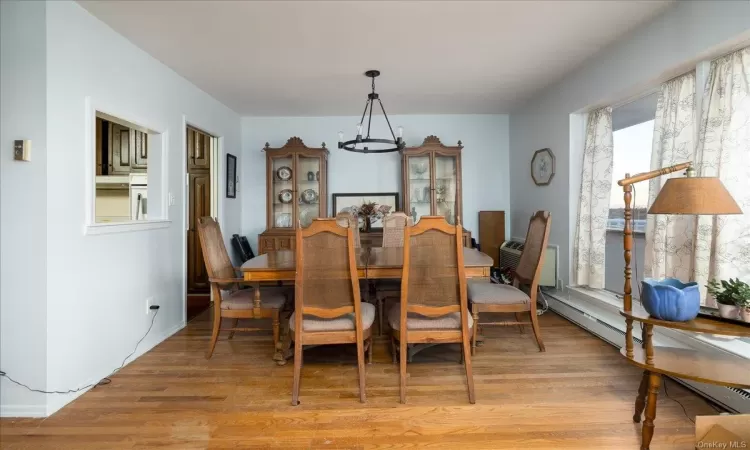 Living room featuring a baseboard heating unit and light wood-type flooring