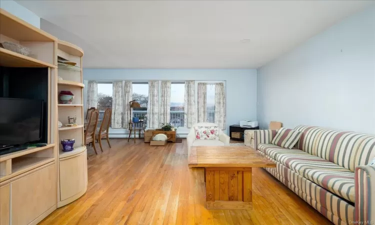 Living room featuring a baseboard heating unit and light wood-type flooring