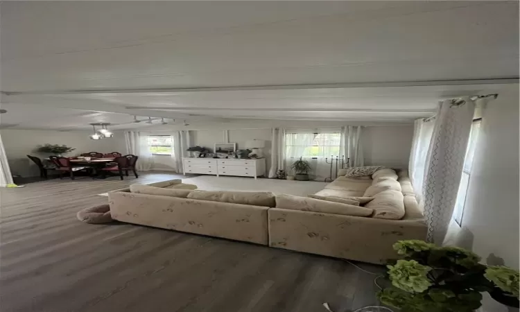 Living room with beamed ceiling, wood-type flooring, and plenty of natural light