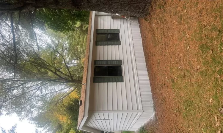 View of side of home featuring a yard