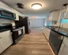 Kitchen featuring light hardwood / wood-style flooring, white cabinets, and stove