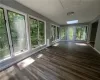 Unfurnished sunroom featuring plenty of natural light and a skylight