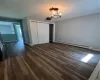 Unfurnished bedroom featuring a baseboard heating unit, a chandelier, dark hardwood / wood-style floors, and a closet