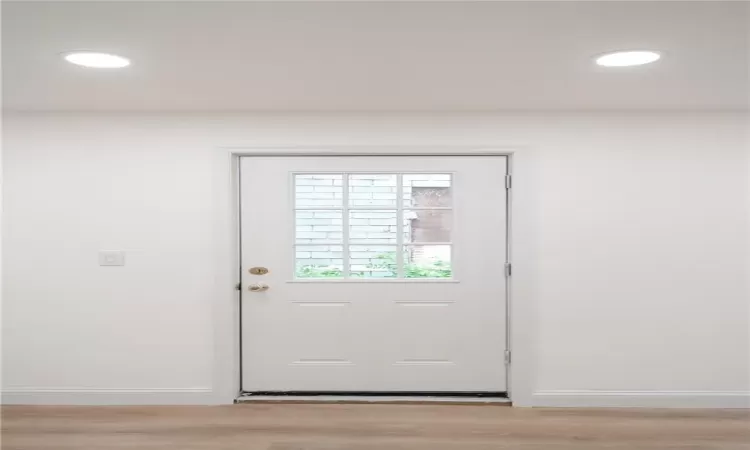 Doorway with light hardwood / wood-style floors