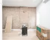 Empty room with brick wall, a wall mounted AC, and light wood-type flooring