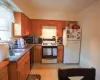 Kitchen with sink, light tile flooring, white appliances, and backsplash