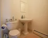 Bathroom with tile flooring, baseboard heating, and toilet