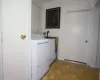 Clothes washing area featuring independent washer and dryer and light tile floors