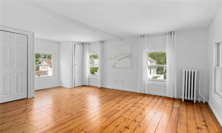 Spare room featuring light wood-type flooring and radiator