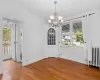 Unfurnished dining area with ornamental molding, a notable chandelier, radiator, and hardwood / wood-style floors