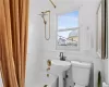 Bathroom with tile walls, toilet, and shower / bathtub combination with curtain