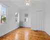 Empty room featuring radiator, light wood-type flooring, and a healthy amount of sunlight