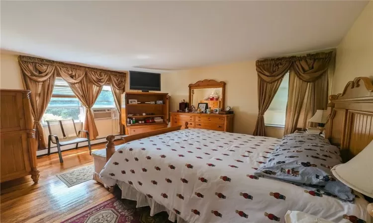 Bedroom featuring baseboard heating and hardwood / wood-style flooring