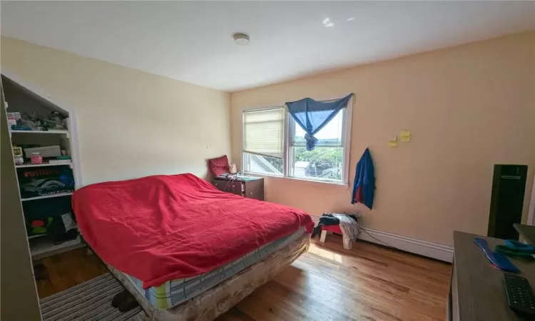 Bedroom featuring hardwood / wood-style flooring and a baseboard radiator