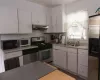 Kitchen with appliances with stainless steel finishes, sink, and white cabinetry