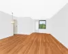 Spare room featuring light wood-type flooring and a chandelier