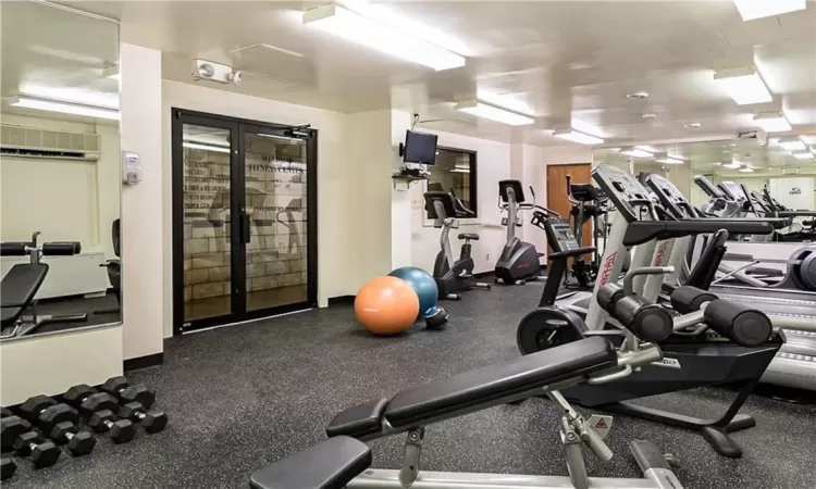 Exercise room featuring an AC wall unit