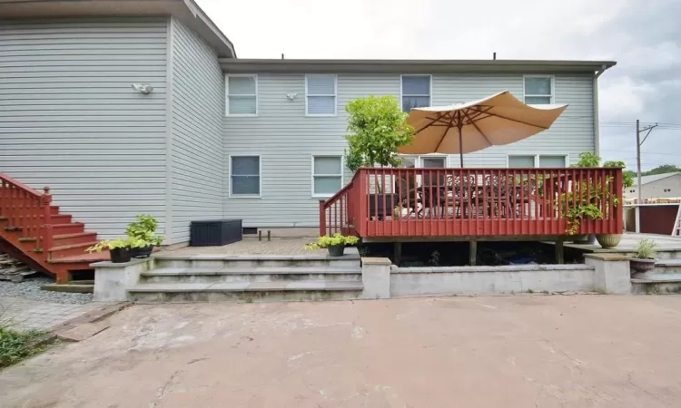 Back of house with a wooden deck and a patio area