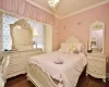 Bedroom with ornamental molding, dark wood-type flooring, and multiple windows