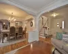 Living room featuring ornamental molding, hardwood / wood-style floors, a chandelier, and ornate columns