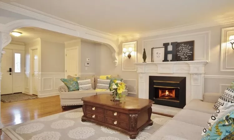 Living room featuring crown molding and light hardwood / wood-style floors