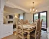 Dining space featuring hardwood / wood-style floors, a fireplace, an inviting chandelier, and crown molding