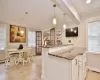 Kitchen featuring light tile patterned floors, crown molding, stone counters, kitchen peninsula, and pendant lighting