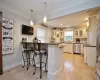 Kitchen with dishwasher, pendant lighting, crown molding, and dark stone countertops