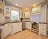 Kitchen featuring stainless steel appliances, backsplash, and white cabinetry