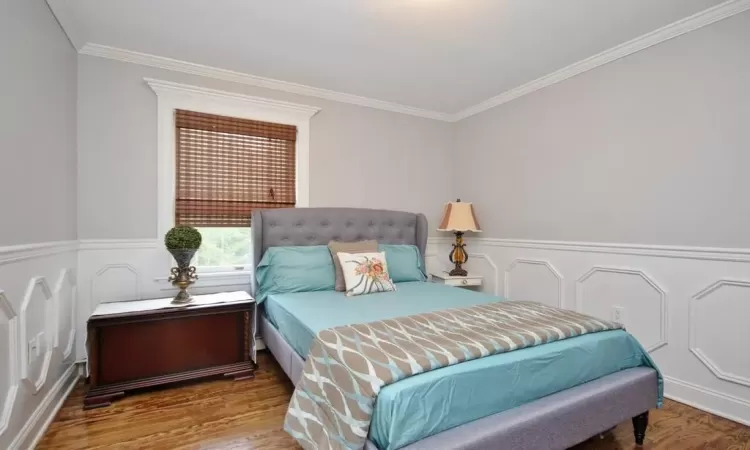 Bedroom featuring ornamental molding and hardwood / wood-style flooring