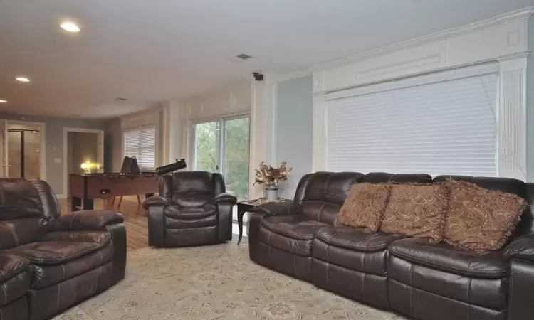 Living room with crown molding and light hardwood / wood-style flooring