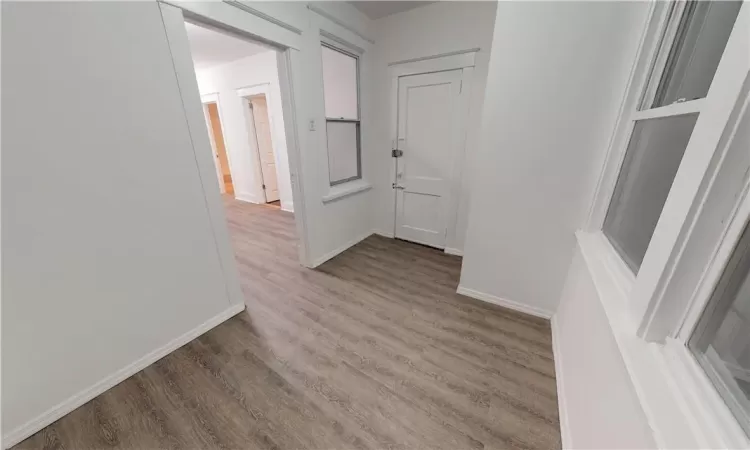 Hallway with dark hardwood / wood-style flooring