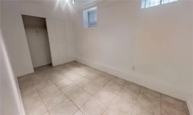 Unfurnished bedroom with light tile patterned floors and a closet