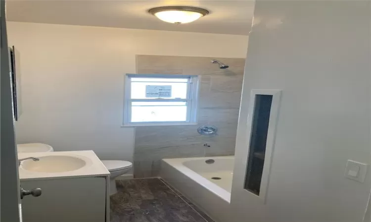 Full bathroom featuring tiled shower / bath, vanity, toilet, and hardwood / wood-style floors