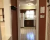 Kitchen with light tile patterned floors, white appliances, dark brown cabinets, and sink