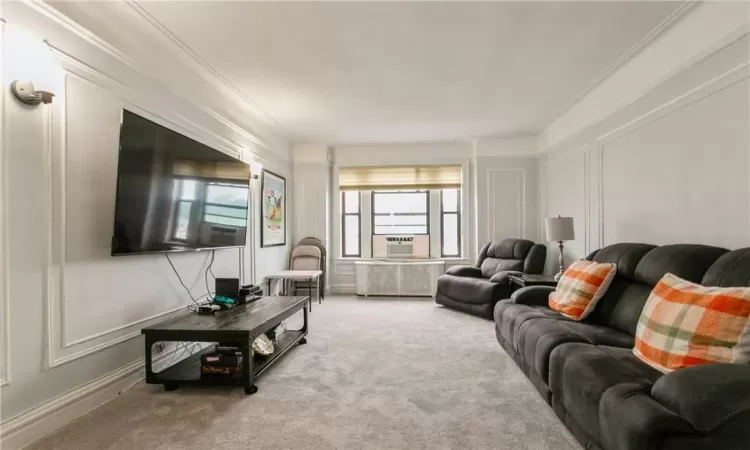 Living room featuring crown molding, light colored carpet, and cooling unit