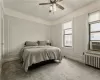 Bedroom featuring carpet flooring, ceiling fan, cooling unit, and radiator