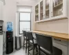 Bar featuring a wealth of natural light, wood counters, light tile patterned floors, and white cabinets