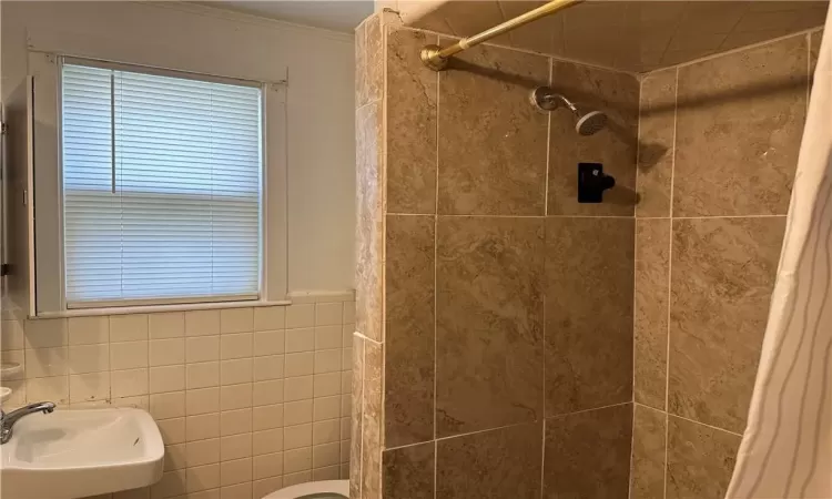 2nd fl Bathroom with curtained shower, crown molding, toilet, sink, and tile walls